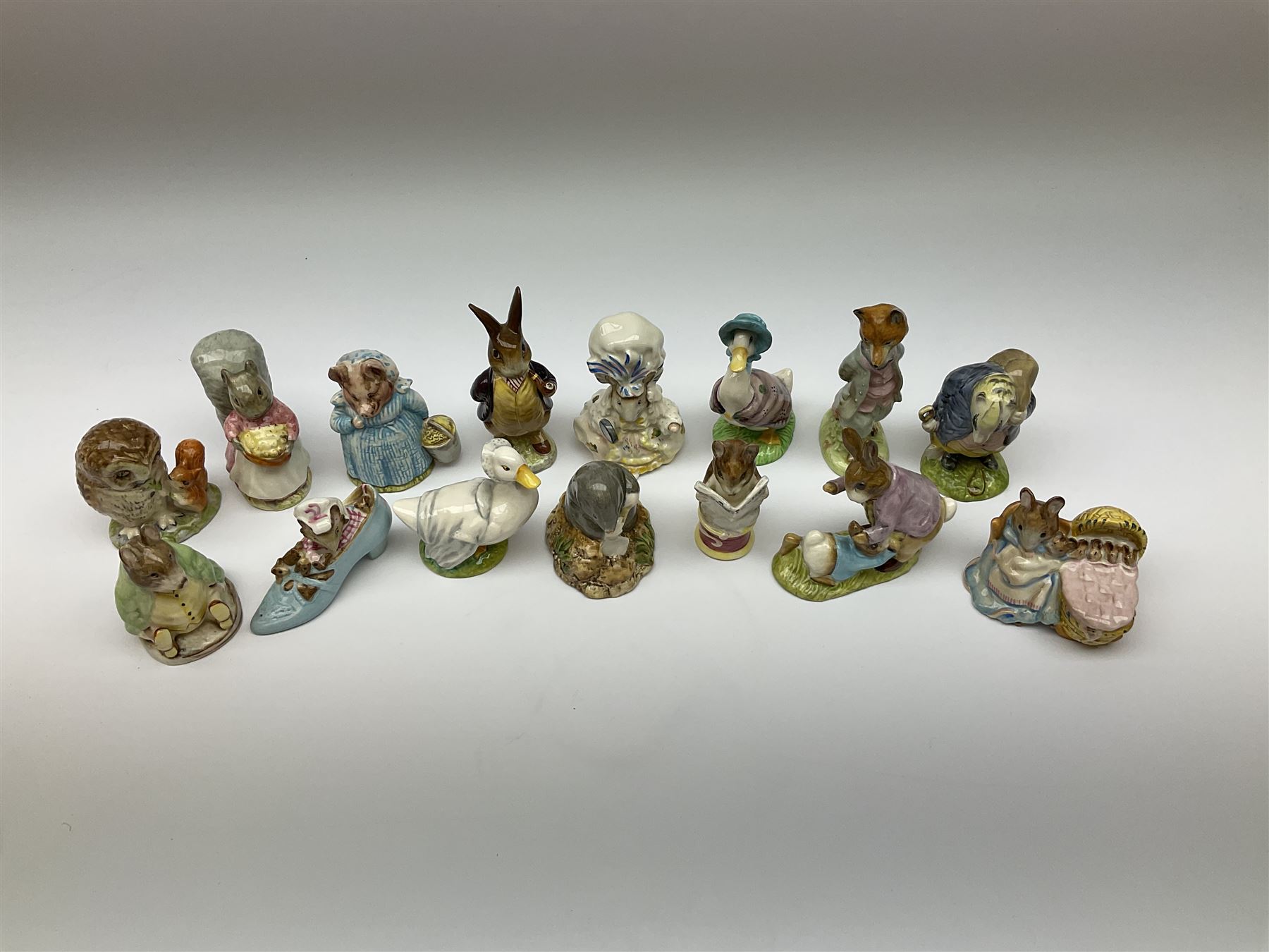 Fifteen Beswick Beatrix Potter figures, comprising Tommy Brock, The Old Woman who live in a Shoe, Samuel Whiskers, Foxy Whiskered Gentleman, Old Mr Brown, Mr Benjamin Bunny and Peter Rabbit, Tailor of Gloucester, Goody Tiptoes, Mr Benjamin Bunny, Diggory Diggory Delvet, Jemima Puddleduck, Aunt Pettitoes, Hunca Munca, Rebeccah Puddle-Duck, and Lady Mouse. 