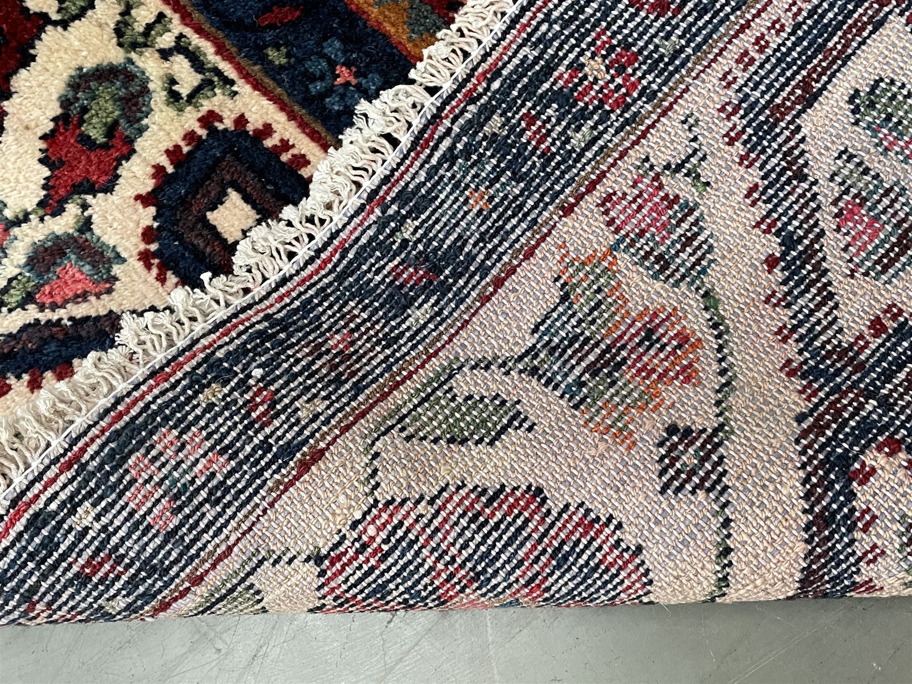 Persian Hamadan rug, the red ground field decorated with two floral medallions and stylised flower heads, repeating guarded border