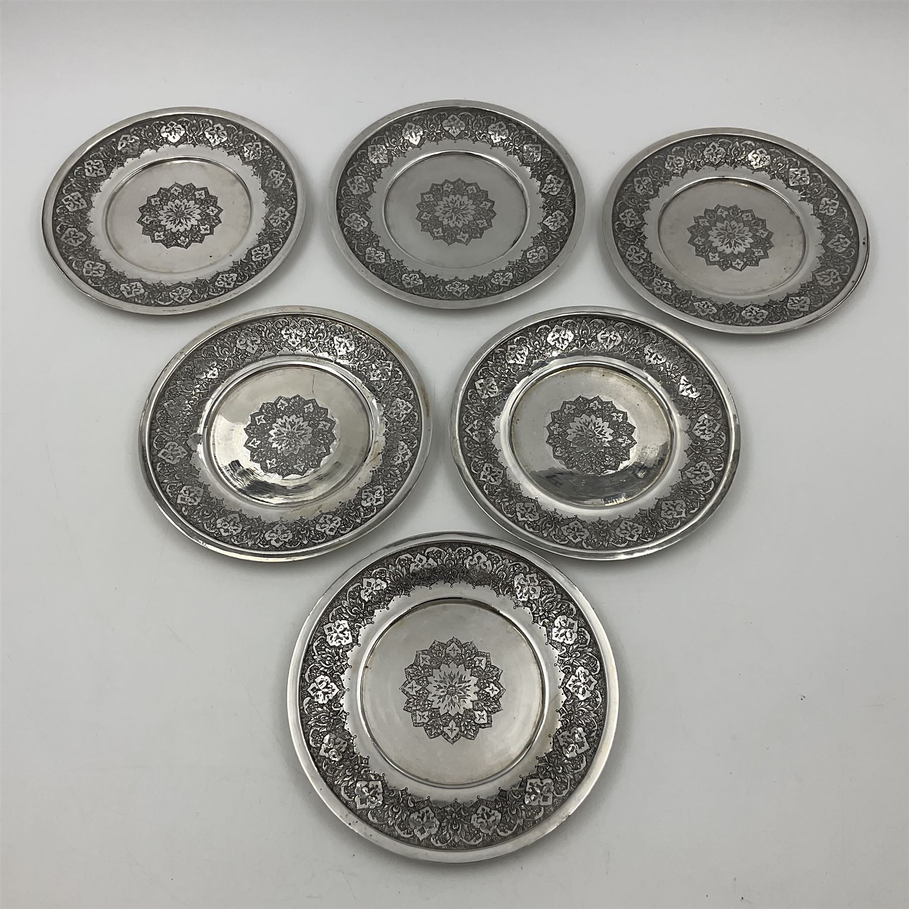 Early/mid 20th century Persian silver tea service, comprising circular serving tray, teapot, twin handled sucrier and cover, milk jug, five tea glasses with six silver holders, six tea spoons, and pair of sugar tongs, each profusely chased with foliate arabesque decoration, each bearing marks including 84 for 840 fineness, tray D40cm, teapot H16cm