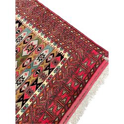 Turkaman red ground rug, the field divided into horizontal rows and decorated with geometric motifs, intricately pattern borders and end panels