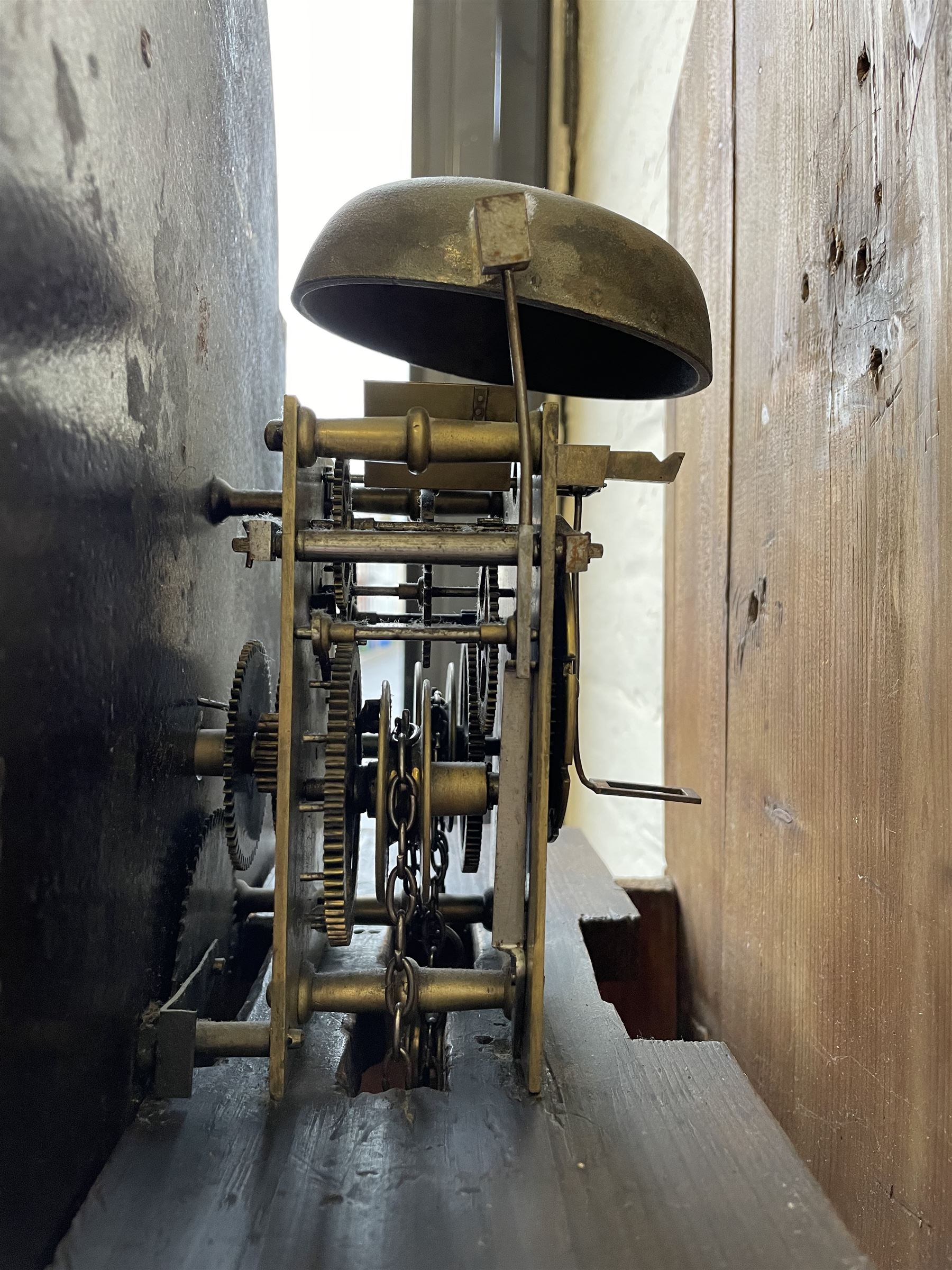 Thirty-hour oak cased longcase clock by  William Bancroft of Scarborough circa 1830, with a swan’s neck pediment, brass patera and three brass spire and ball finials, stepped break arch hood door flanked by plain pillars with brass capitals, trunk with a full length door and curved arch top, on a plain square plinth with bracket feet, painted break arch dial with roman numerals and quarter hour Arabic’s, date recorder (anti clockwise) and matching brass hands, arch painted with a rural scene depicting a ruined tower and cottage with depictions of flowers to the spandrels, dial pinned directly to a chain driven countwheel striking movement, striking the hours on a bell. With weight and pendulum. The Bancroft family were prodigious Scarborough clockmakers during the 18th and 19th century, William Bancroft is recorded as working in Newborough Street from 1820 onwards. 


