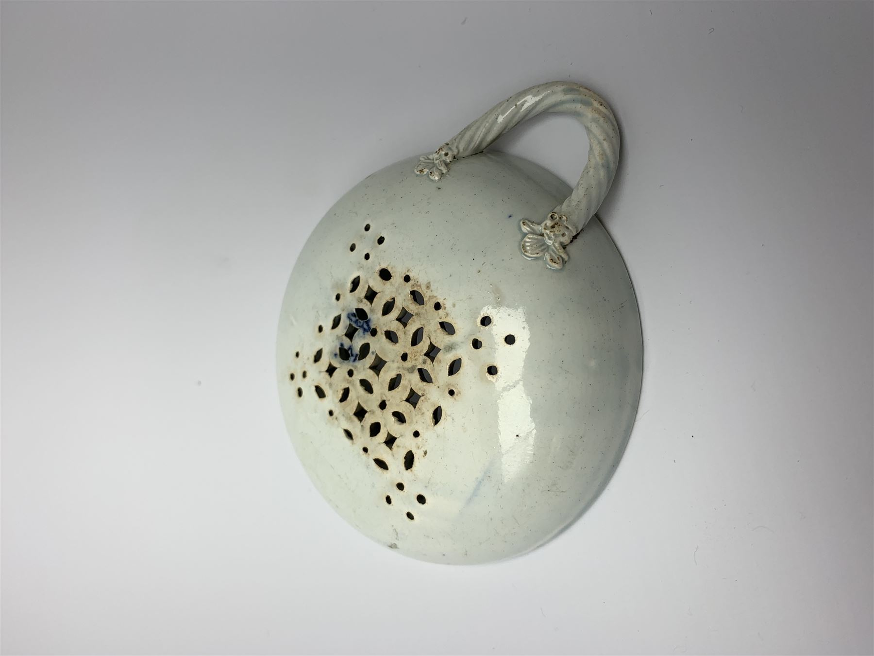 Late 18th/early 19th century Leeds Pottery egg drainer, the pierced bowl of circular form decorated with blue transfer printed floral spray and floral border, the twisted handle with foliate mounts, bowl D9cm