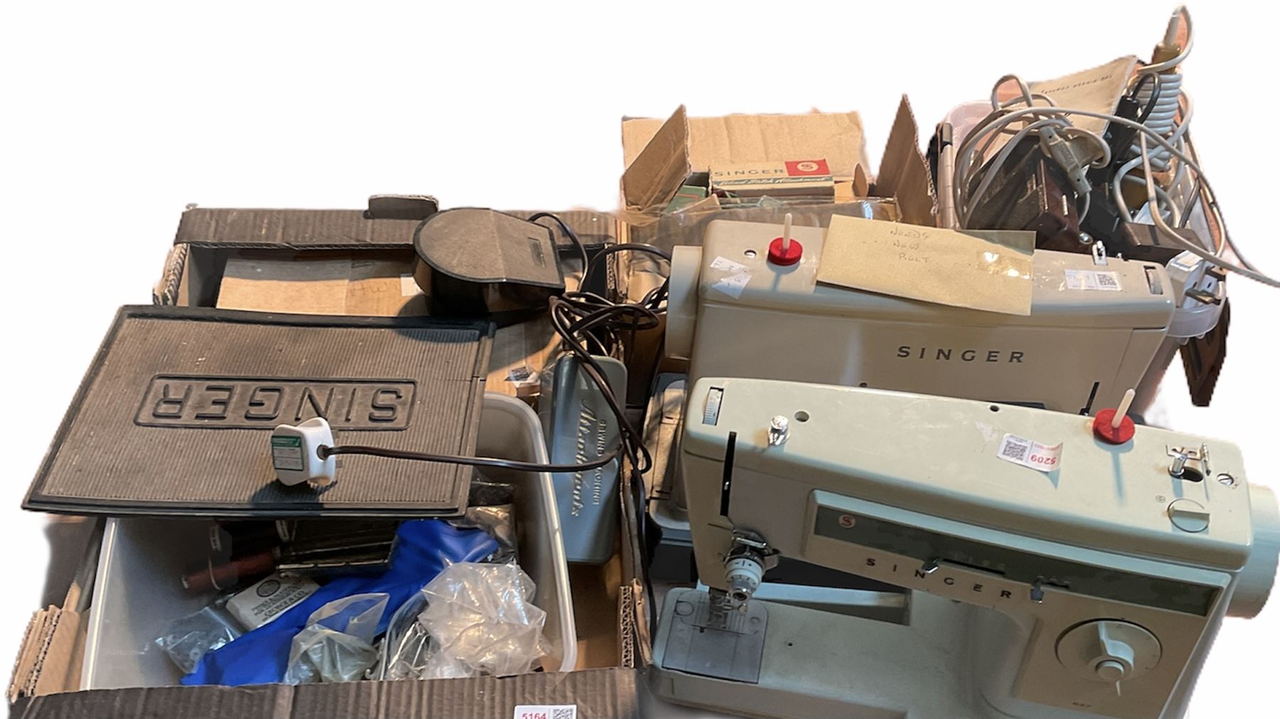 Two Singer sewing machines, model numbers 527 and 457, together with various Singer sewing machine parts, and a selection of sewing related accessories, to include threads, sewing needles, etc.