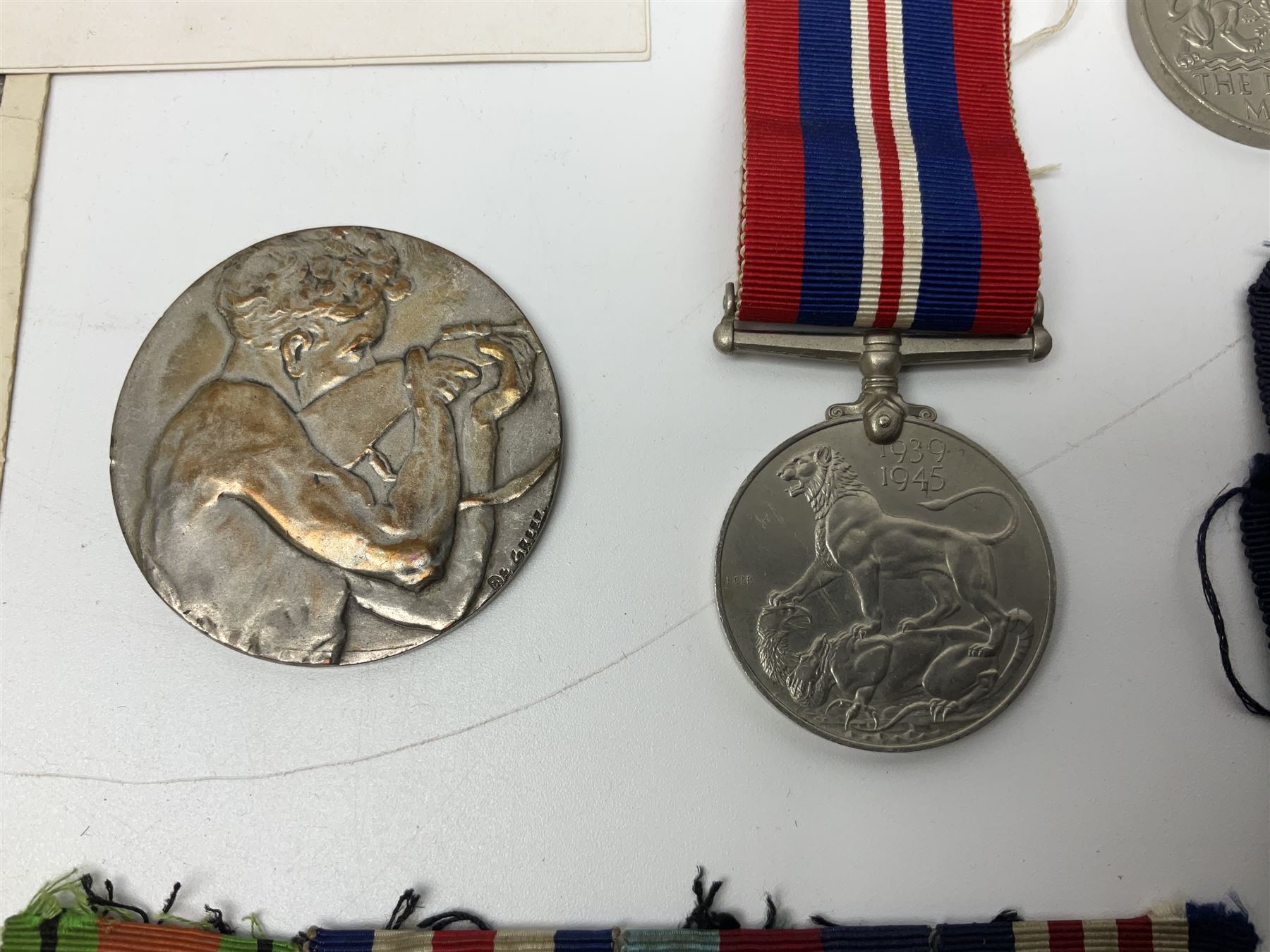 WW2 Highland Light Infantry Military Medal group of five comprising MM, 1939-1945 War Medal, Defence Medal, 1939-1945 Star and France and Germany Star; three with ribbons; awarded to 1702538 A. Sjt. A.L. Alden H.L.I.; various copies of his citation giving details of his bravery on 26 Sep 44 at Donderdonk France when he single-handedly silenced an enemy machine gun nest. The citation also mentions a further heroic act on 15 Nov 44 when he risked his life to obtain vital information on the position of enemy mines and booby traps saving the lives of many other soldiers; the collection also comes with two contemporary group photographs of his Highland Light Infantry regiment, copy photograph of him being awarded the MM by Field-Marshall Montgomery, two post-war tug-o-war medallions and other items; together with a shooting medallion awarded to Gnr. J. Alden (his brother John) inscribed 123 L.A.A. Regt. R.A. Rifle Meeting Harburg 1945 and a Life Saving bronze medallion to J. Alden April 1938