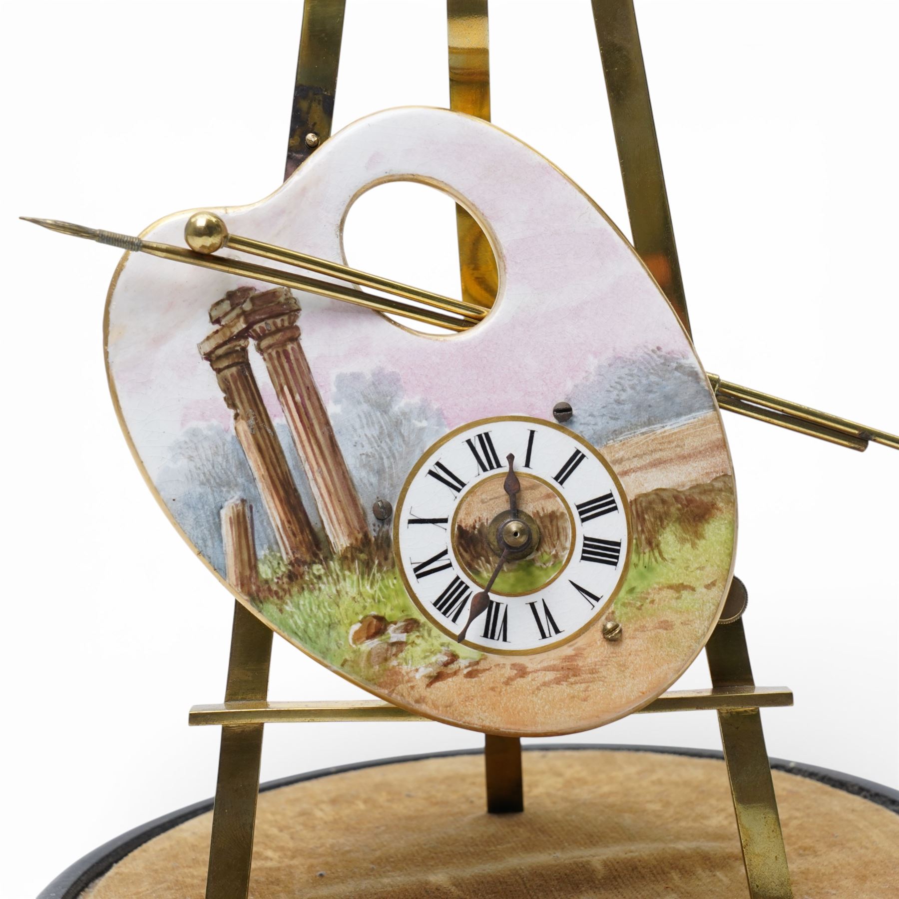 Late 19th century French novelty easel clock, the shaped panel in the form of an artist's palette painted with a landscape with classical columns on a gilt brass easel under a glass dome shade H33cm overall