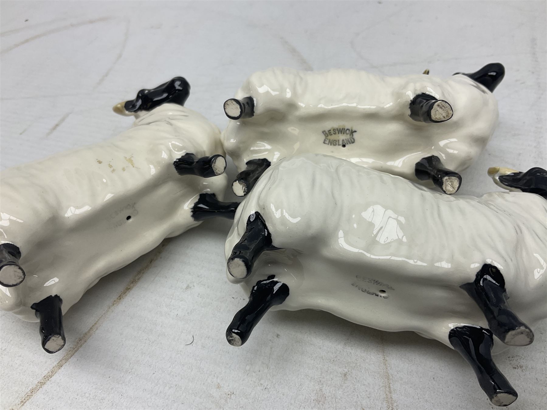 Seven Beswick figures of sheep comprising three ewes and four lambs, together with a figure of a sheepdog (8)