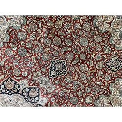 Persian silk finely knotted rug, central floral rosette medallion surrounded by curling branches decorated with palmettes, repeating pattern borders decorated with stylised plants and trailing leafy branches  