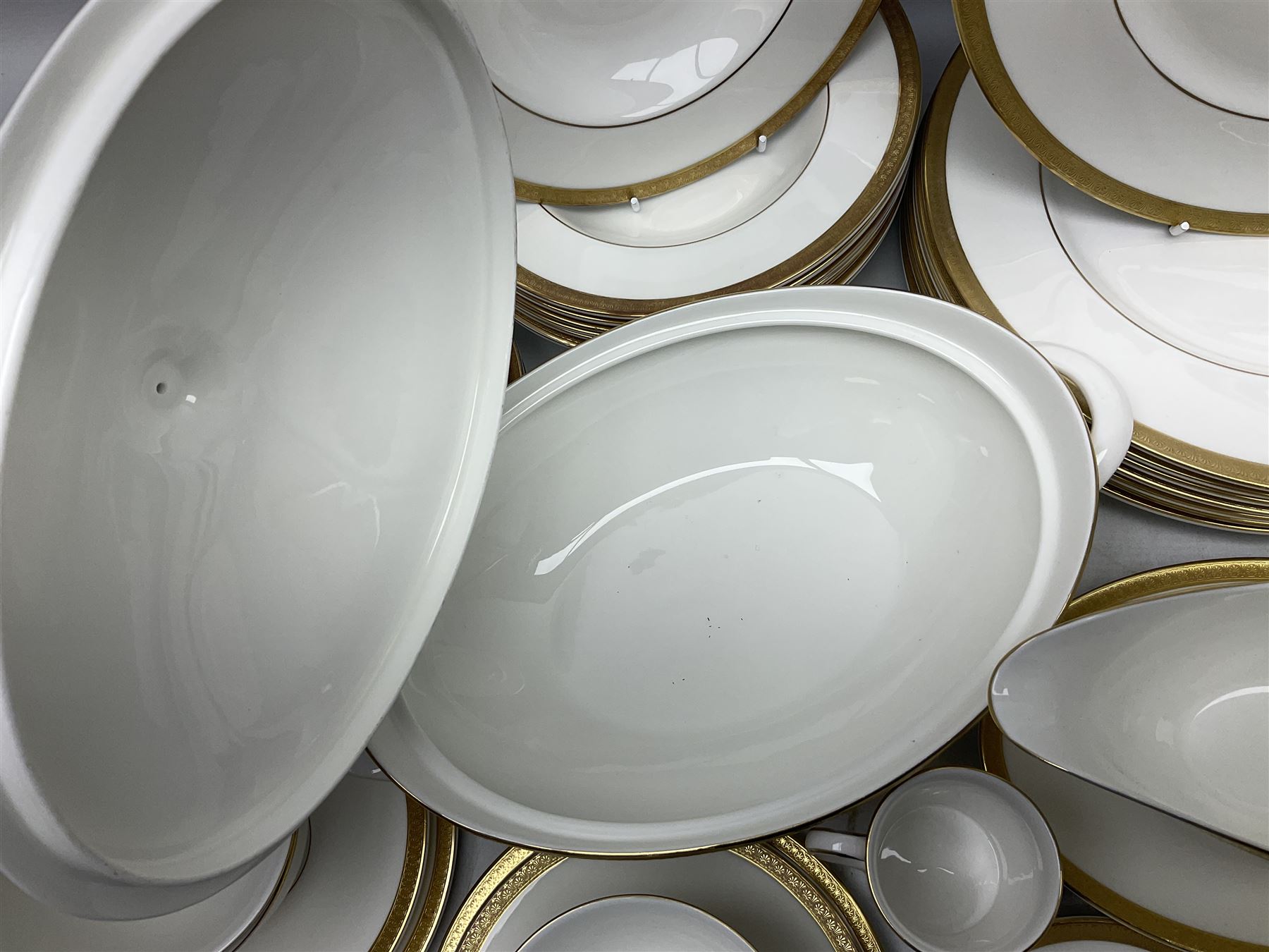 Royal Doulton Royal Gold pattern tea and dinner service for eight, comprising dinner plates, side plates, tea plates, soup bowls, sauce boat and saucer, dessert bowls, coffee cans and saucers, teacups and saucers and two lidded tureens