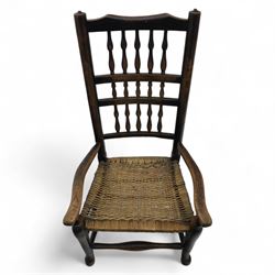19th century country elm spindle back armchair, shaped cresting rail over two rows of turned spindles, shaped open arms over rush seat, on front turned supports, joined by stretchers 