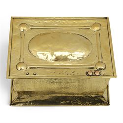 Art Nouveau brass coal box, the hinged rectangular cover embossed with a foliate design, hammered panelled sides with shaped carrying handles, on projecting plinth base with applied roundels