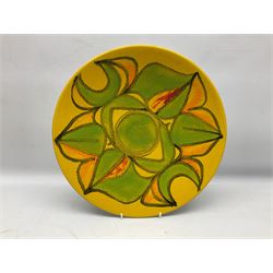 Poole Pottery charger, with a stylised floral pattern on a yellow ground, together with a Poole pin dish and vase of a similar style, vase H21cm
