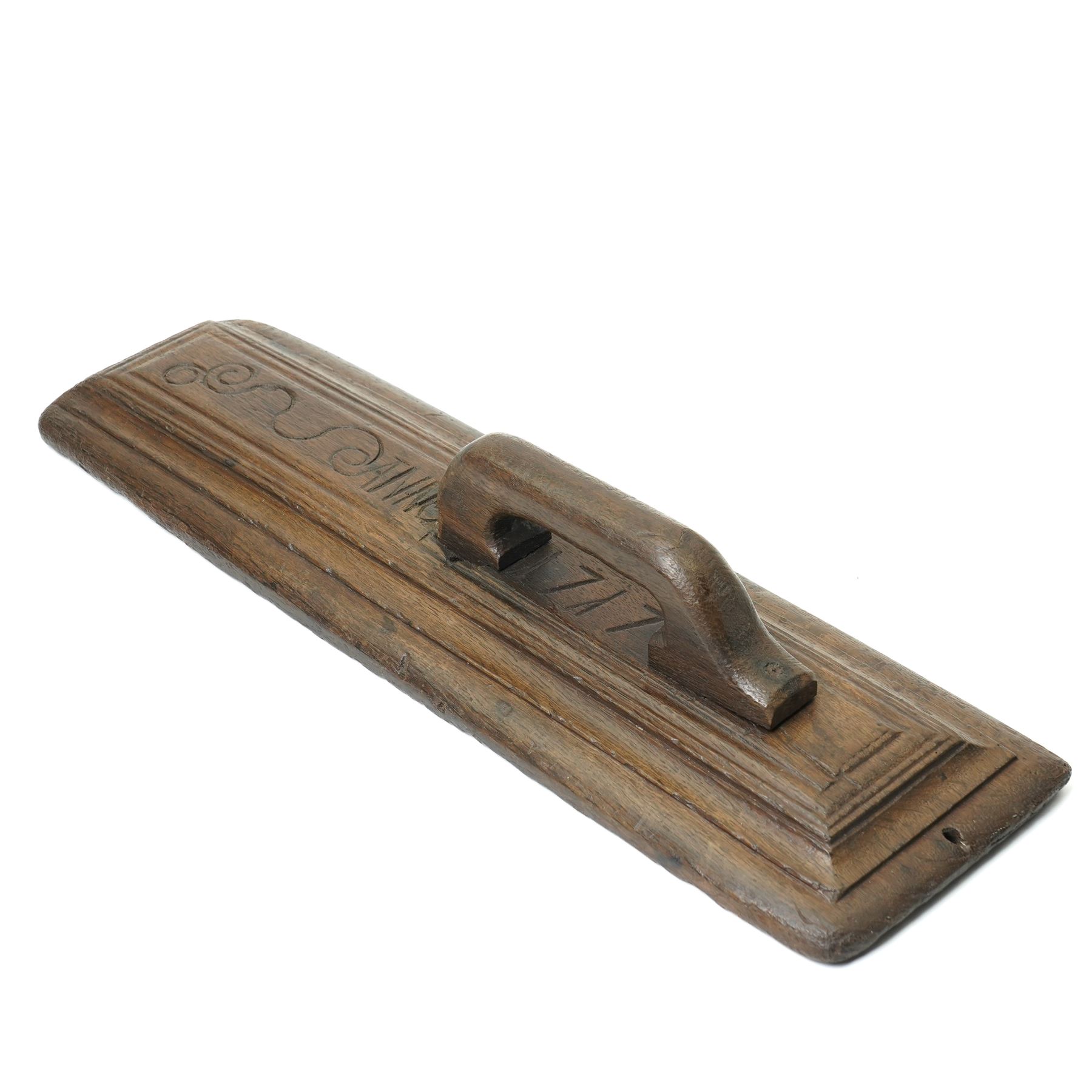 18th century oak mangle board, carved with scrolled motifs, incised 'ANNO 1717', W57cm 