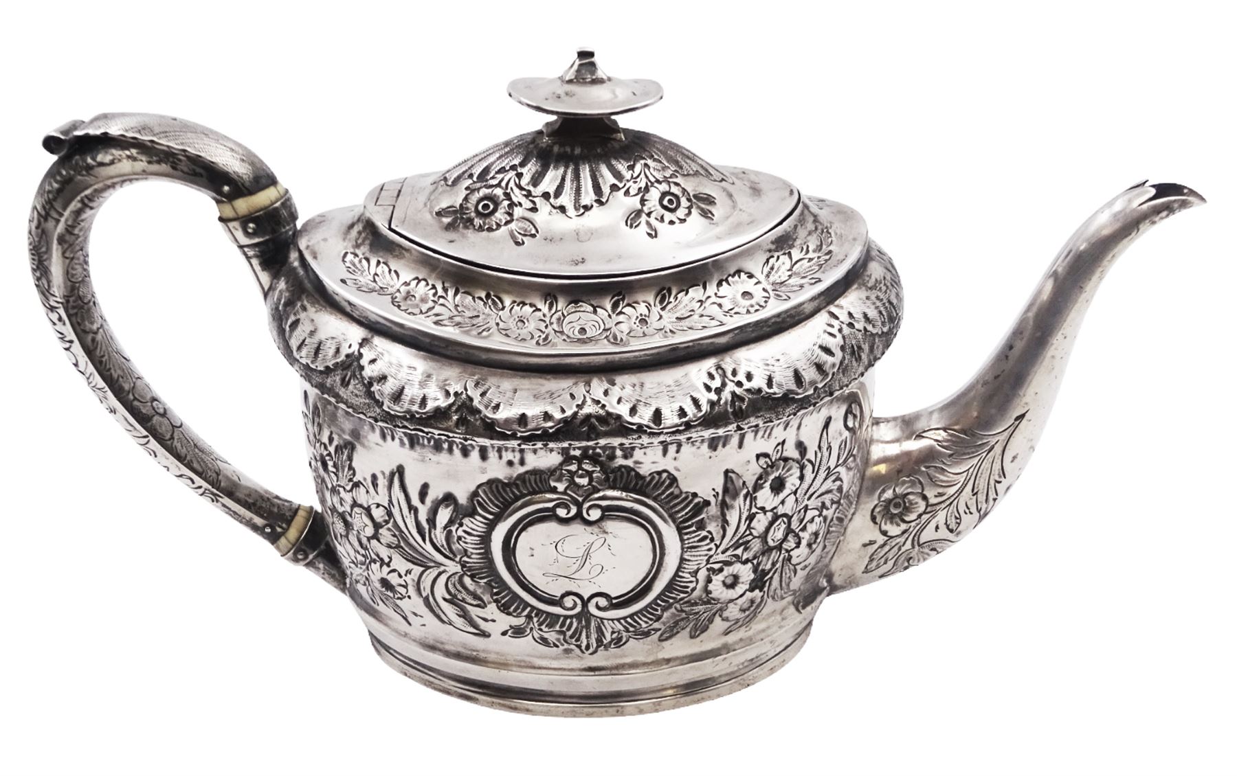 George III silver teapot, of oval form, with embossed foliate, floral and scroll decoration and engraved central cartouche, with acanthus capped C handle with ivory insulators, hallmarked John Emes, London 1807 This item has been registered for sale under Section 10 of the APHA Ivory Act
