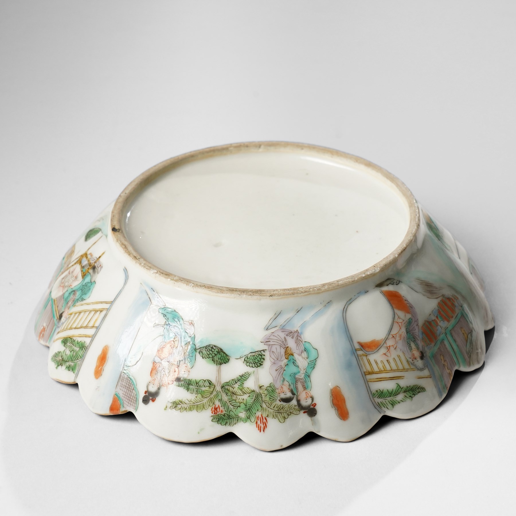 Chinese Kangxi period famille verte bowl, painted with seven figures in a pavilion interior, in Cantonese style border with foliate rim, the exterior painted with similar scenes, D24cm