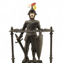Early 20th century painted cast iron hall stand, formed as a standing armoured figure with red and yellow feathered crest, twin rails and integral drip tray with castellated edge