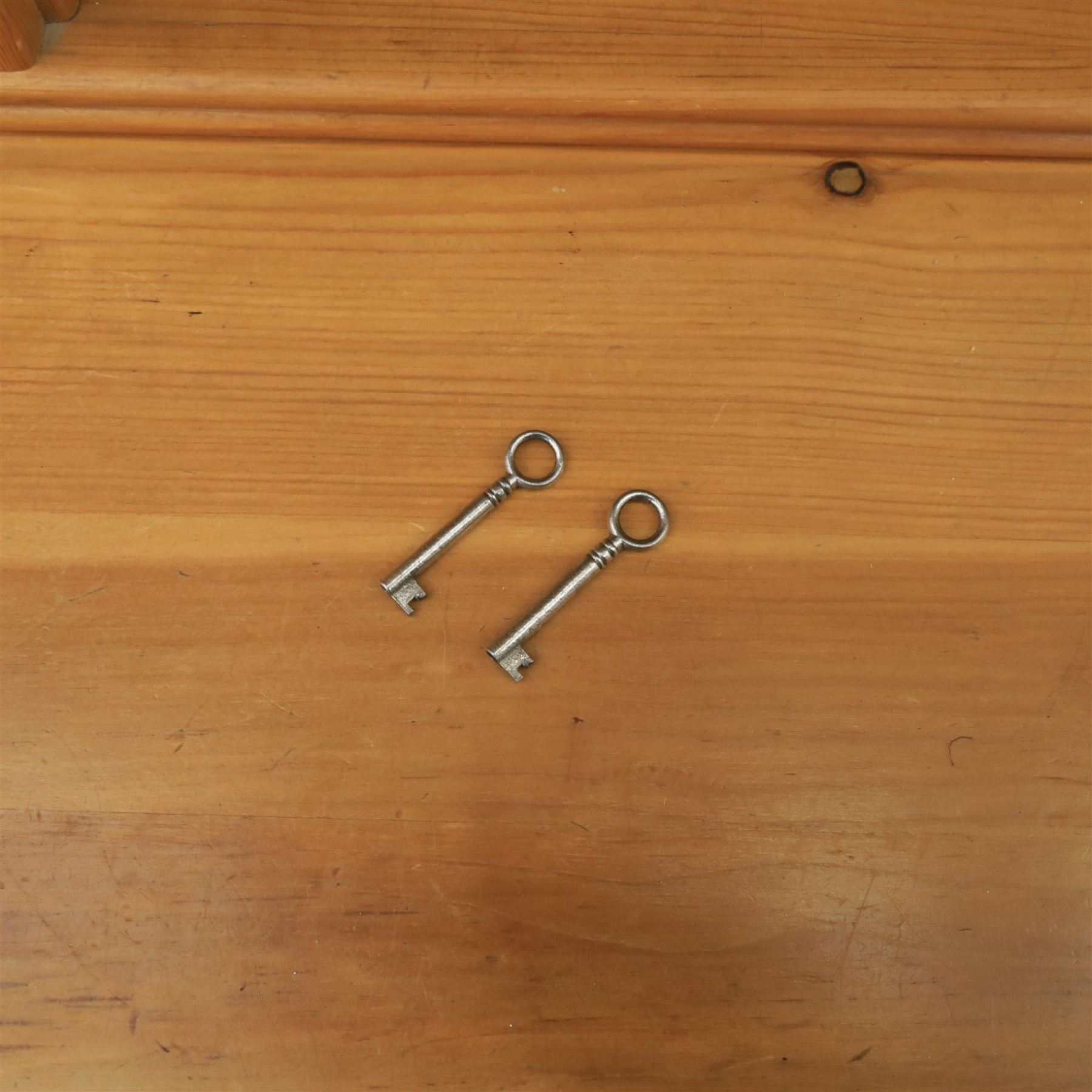 20th century country style waxed pine housekeeper’s cupboard, upper section with moulded cornice, shaped aprons and open shelving around central drawer arrangement, the lower section fitted with three drawers and two cupboards with panelled doors, raised on a plinth base