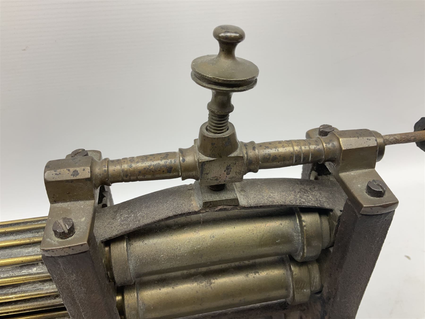 Victorian cuff and collar tabletop mangle, the ribbed brass rollers in a cast iron frame mounted on a wooden base