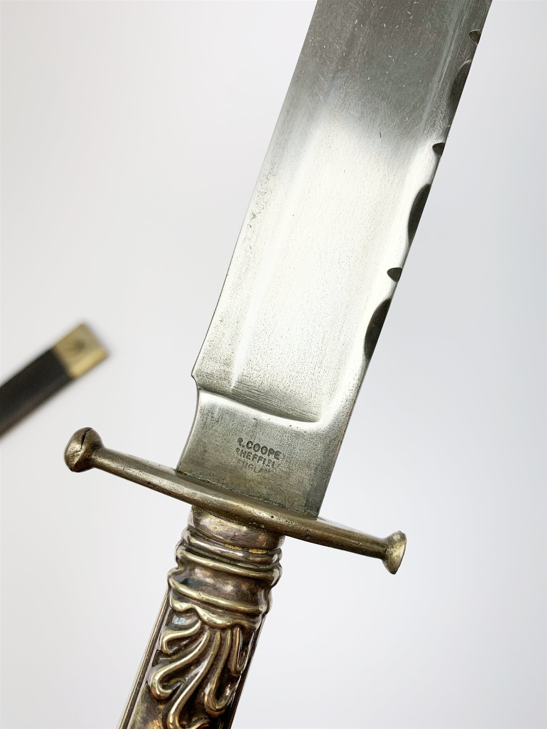 Large Bowie knife, the 20cm steel blade marked R. Coope(r?) Sheffield England, with plated crosspiece and pistol grip embossed with scrolls and anthemion, in plated and leather scabbard L33cm overall