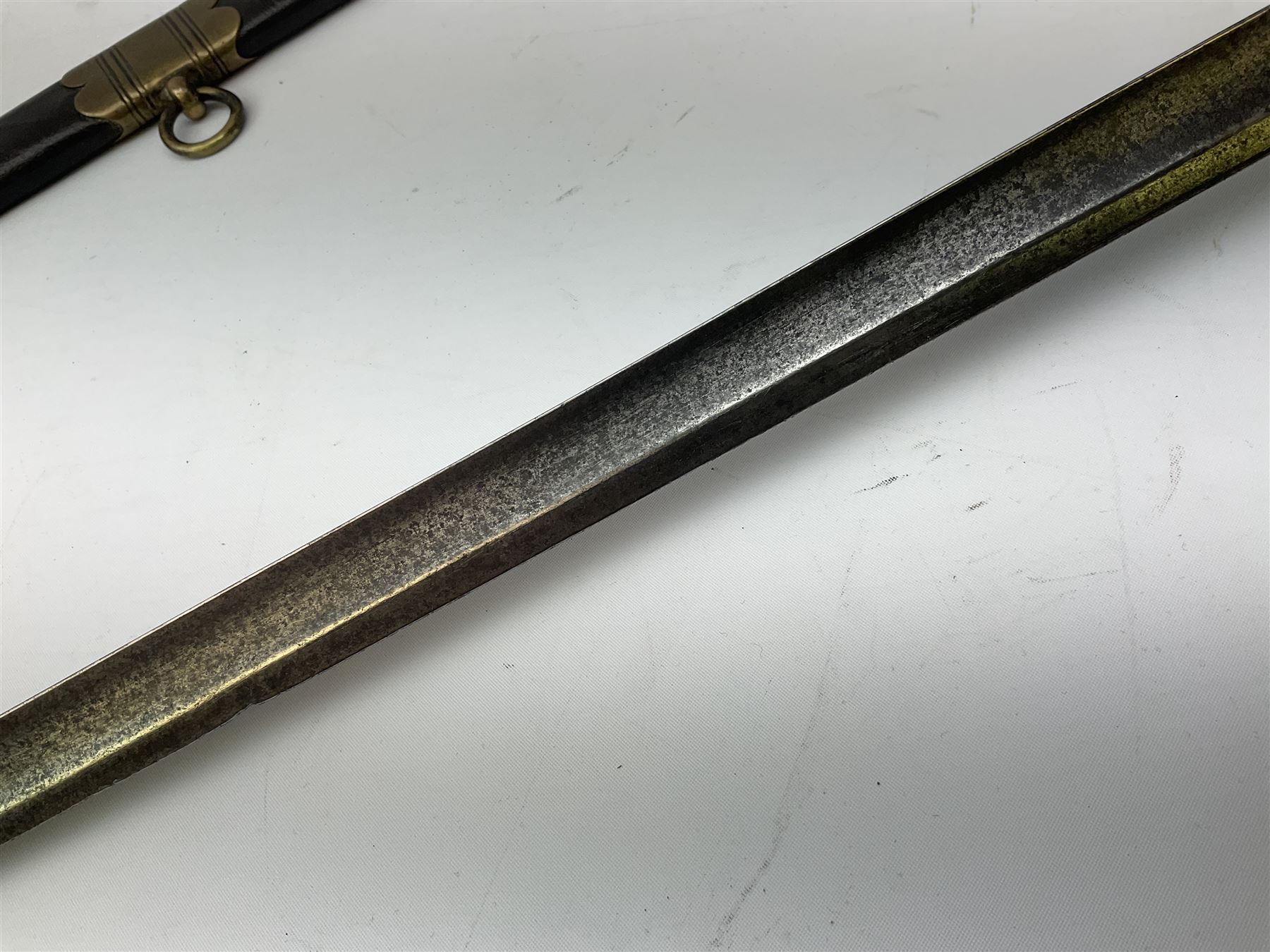 Five-ball spadroon sword with 78.5cm fullered steel blade and brass hilt with fluted swollen grip; in brass mounted leather scabbard, the locket with traces of the makers name John Knubley 11 Charing Cross L97.5cm overall