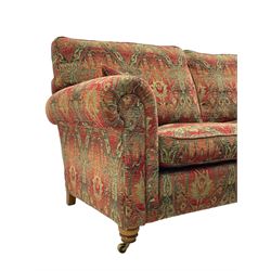 Duresta - 'Beaminster' grande two-seat sofa, traditional shape with rolled arms, upholstered in 'Althorp' russet and stone floral pattern fabric, on turned feet with brass castors
