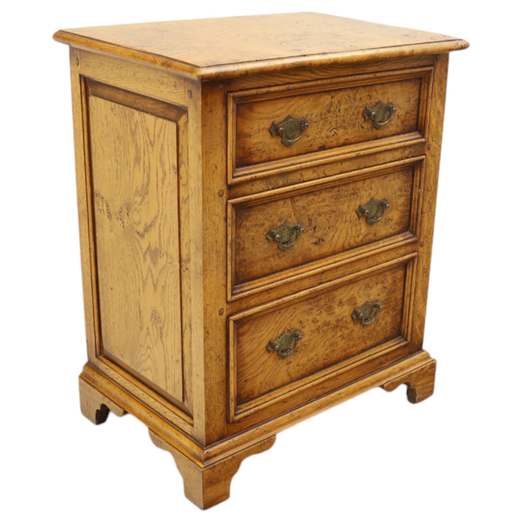 Small 20th century burr oak chest, the figured top over three graduated drawers with moulded fronts and pierced brass handles, on shaped feet