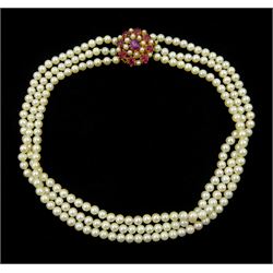 Three strand cultured pearl, with 14ct gold oval cabochon and oval facet ruby and pearl clasp