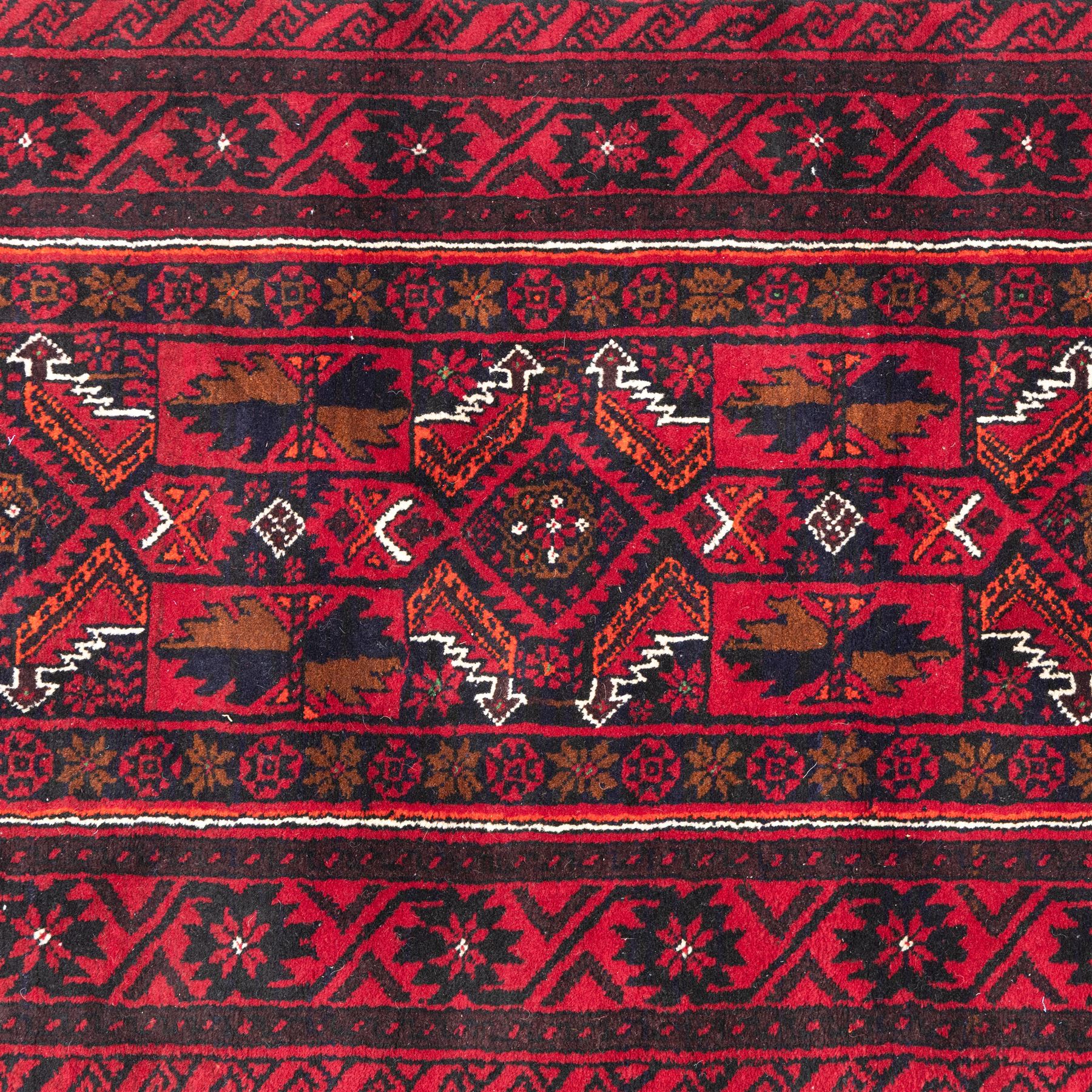 North east Persian Baluch hand-knotted runner, crimson ground with a vertical column of hooked lozenge medallions flanked by stylized leaf motifs within multiple geometric borders of rosettes and angular vines  