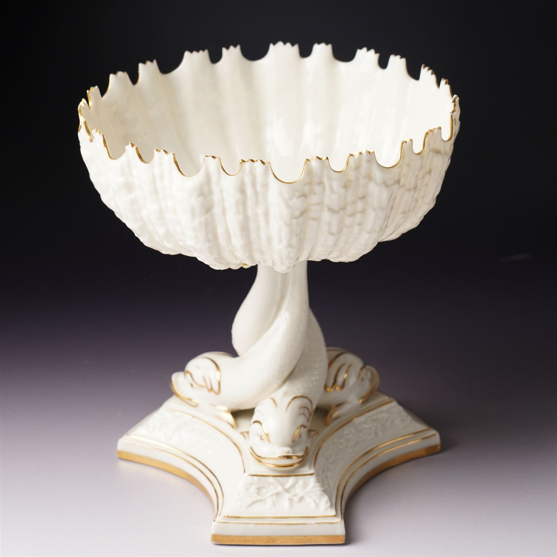 19th century Royal Worcester comport, painted with gilt on a cream ground, the stem formed as three entwined dolphins raising the shell shaped bowl, faint mark to base, H19.5cm