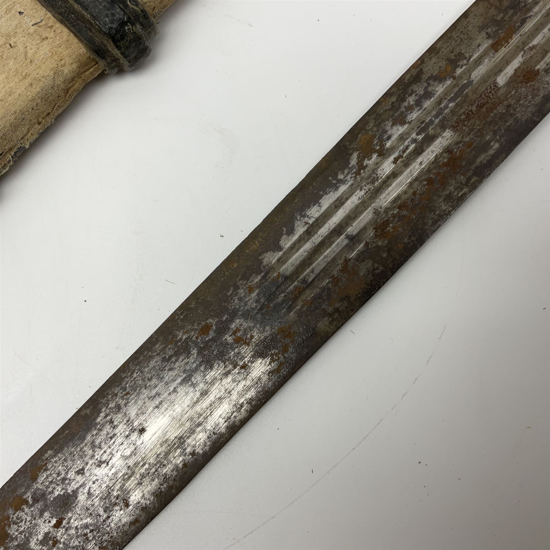 African Mandingo sword, the 75cm triple fullered blade with leather covered grip and brass pommel, in part leather covered scabbard with leaf shaped point L98cm overall