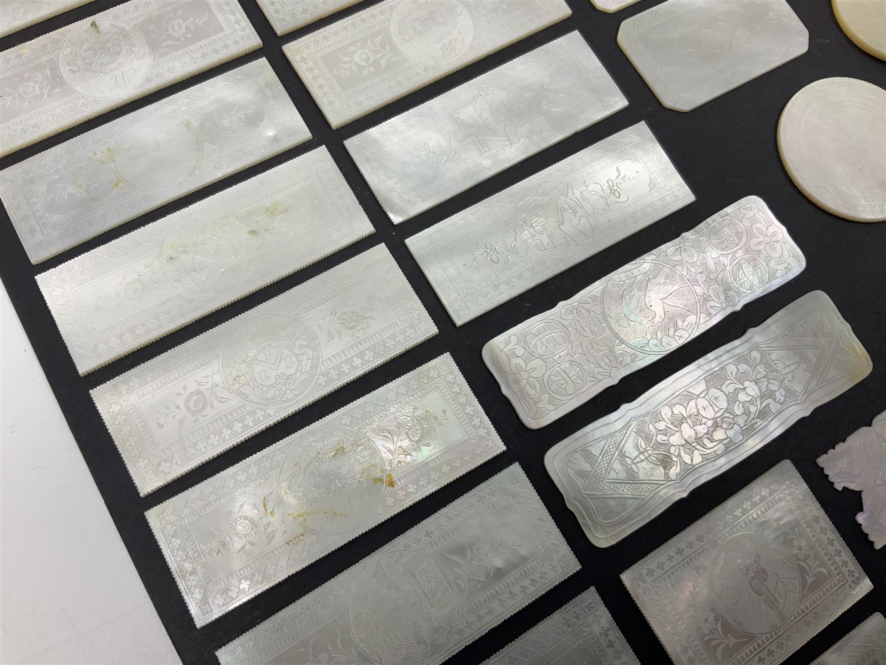 Collection of fifty seven Chinese mother of pearl gaming counters or tokens, of various size and form including rectangular, circular and fish shaped examples, various decoration including floral motifs, largest rectangular examples L6cm