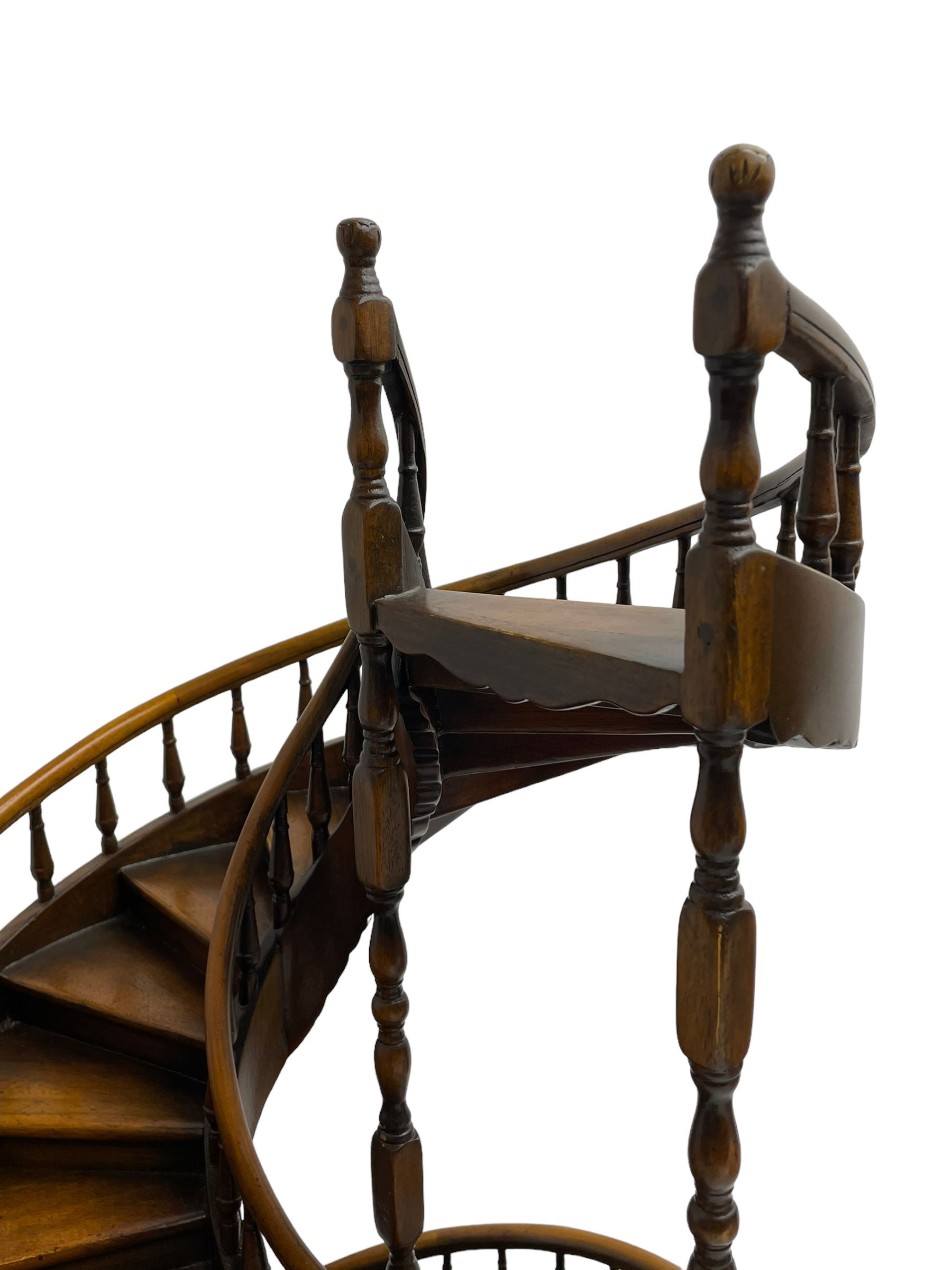 Miniature fruitwood spiral staircase, turned newel posts and balusters, rounded handrail, on circular moulded base