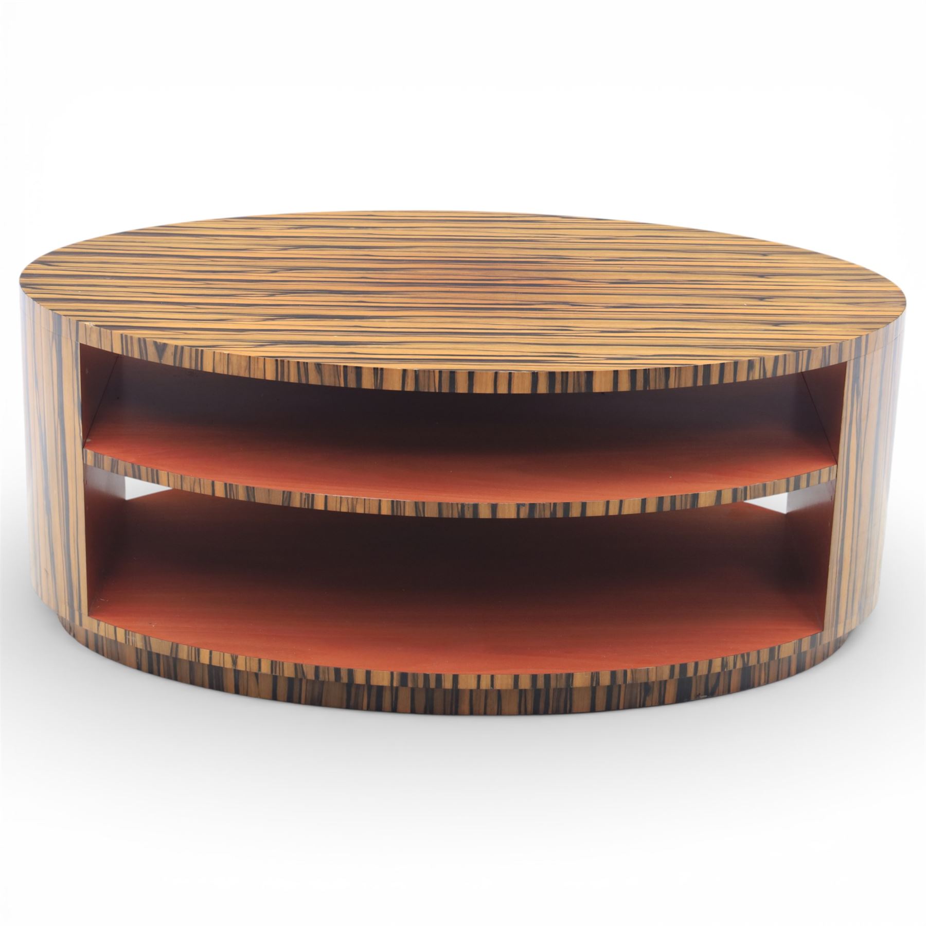 Toby Winteringham - Mid 20th century zebra wood coffee table, oval top with book matched striped veneers over two open tiers painted red, the curved end supports and continuous plinth base veneered to match, recessed plinth base 