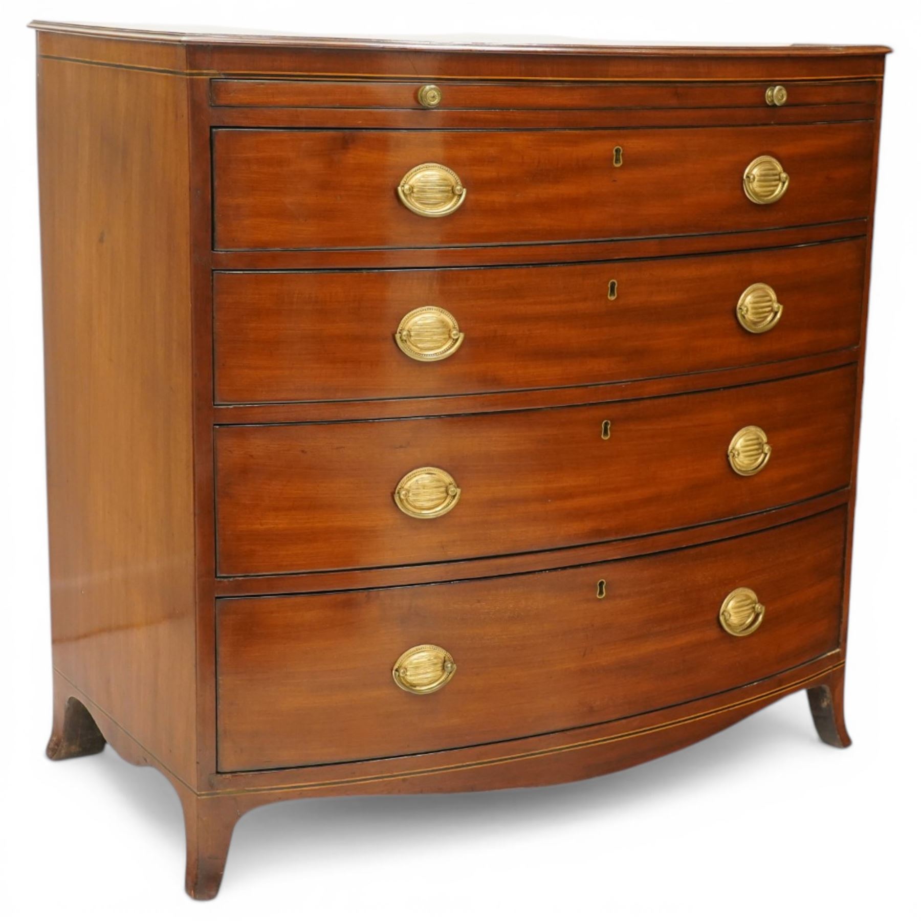 Regency period mahogany bow-front bachelor's chest, shaped top with moulded edge, fitted with brushing slide over four long graduating drawers, each with original pressed brass handle plates, raised on splayed feet 
