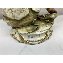 Pair of Capodimonte table lamps, in the form of cherubs holding a brass fitting, together with a pair of large Capodimonte figures in the form or a man and woman resting up on tree stump, largest example H57cm