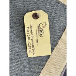 Chinese wool rug, purple ground with tonal floral and foliate pattern, central medallion of stylised flowers, the corners with large rosettes, framed by broad border of scrolling floral and leafy motifs 