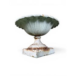 Coalbrookdale - pair of 19th century cast iron petal rim urns, squat form on square plinth, finished in distressed white paint, design registration number 133334, first registered 19 september 1860, number 19 in the Coalbrookdale Castings Catalogue (see illustration)
