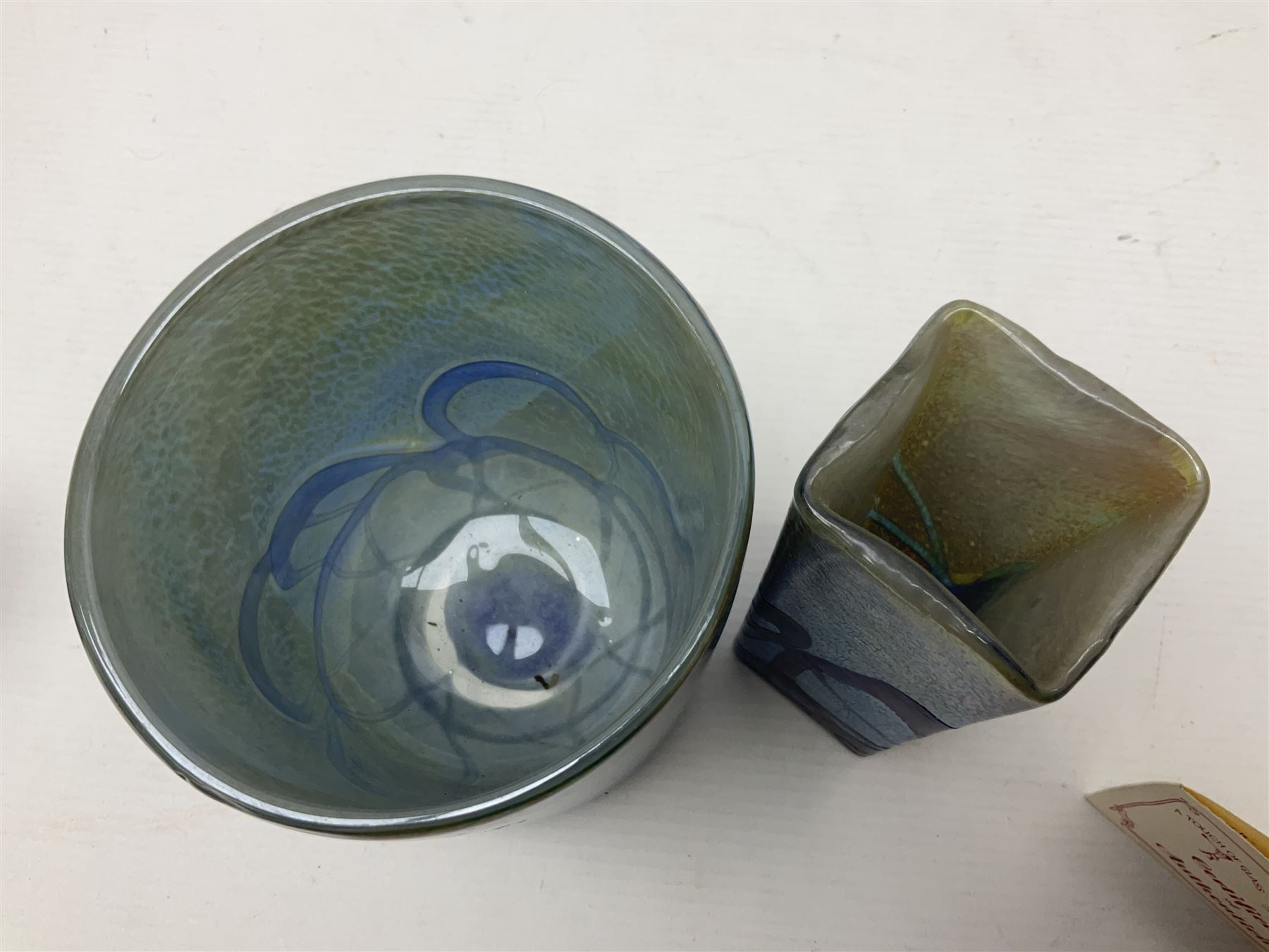 Two Isle of White glass vases, by Alum Bay Glass, both with blue swirl design upon an iridescent mottled blue/green ground, together with a Gozo Glass vase of pebble form, with similar design, H12cm
