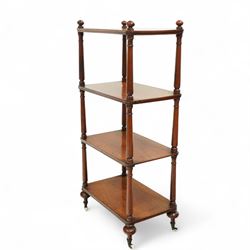 19th century mahogany four-tier whatnot, each rectangular shelf supported by turned uprights with ball finials, raised on turned feet with brass castors