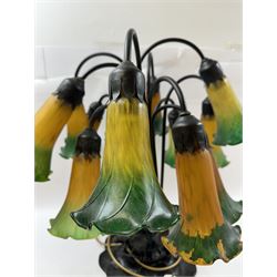 Art Nouveau Tiffany style table lamp, the bronzed base modelled as lily pads leading to tendrils and twelve branches supporting green and yellow glass lily flower shades, H53cm