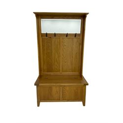 Oak mirror-back hall bench, projecting cornice, rectangular bevelled plate over four coat hooks, hinged box seat compartment with panelled front, on square tapering feet
