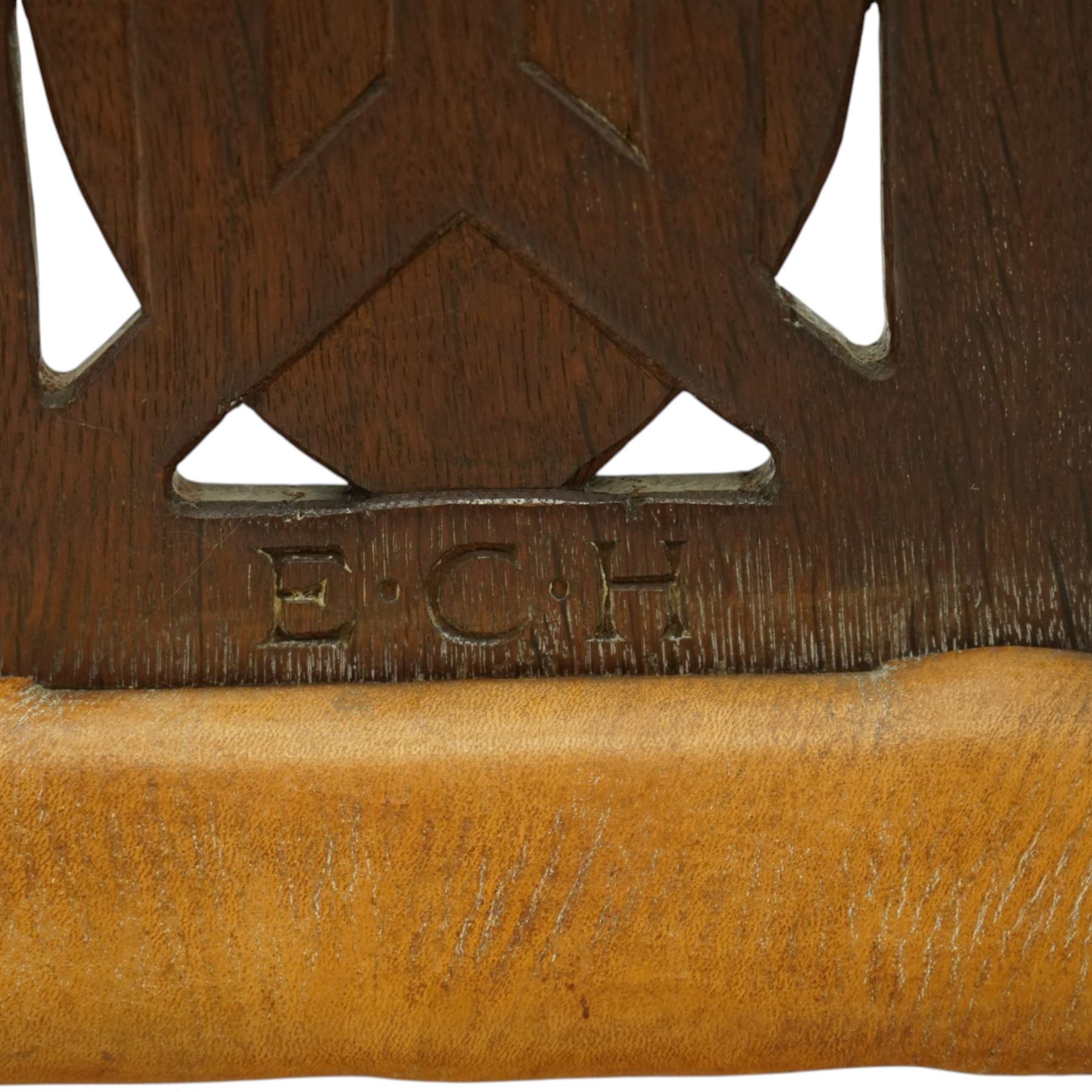 Mouseman - important oak monks chair, c1930s, the curved back inscribed with motto 'Cum Bona Voluntate Servientes' (serving with goodwill) over Trinity College Cambridge coat of arms, the shaped arms terminating with carved monks heads, each pierced side panel with Yorkshire Rose, tan leather seat on four octagonal legs joined by a cross stretcher, the back of the chair with initials ECH, with carved mouse signature, by Robert Thompson of Kilburn