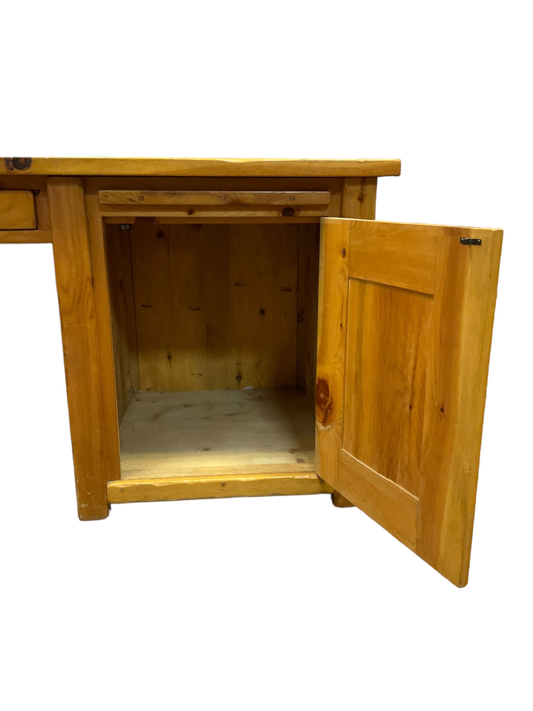 Large pine desk, rectangular top over four drawers, slide and panelled cupboard