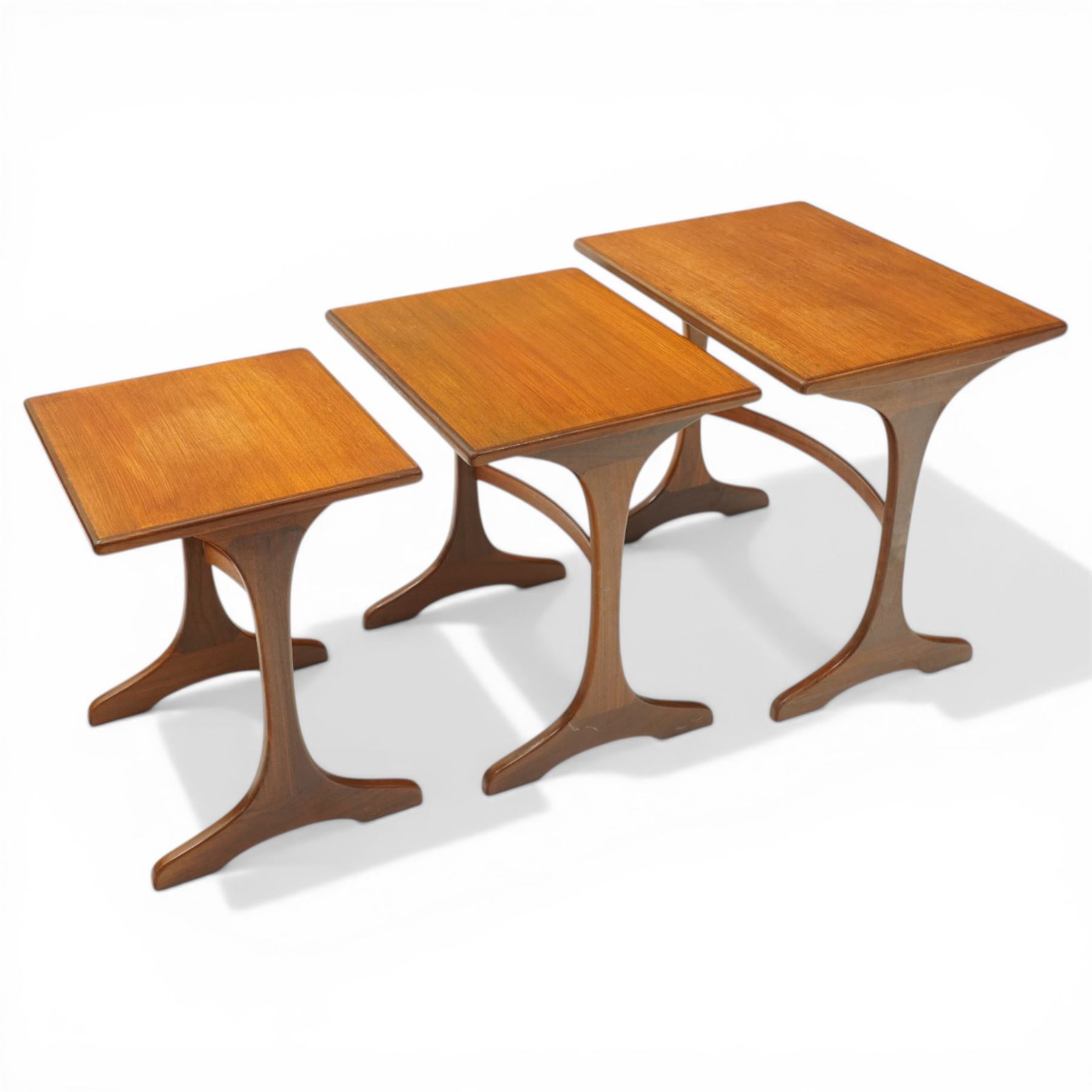 Victor Wilkins for G-Plan - 1970s teak 'Fresco' nest of three tables, rectangular top over vasiform end-supports with sledge feet, united by curved stretchers