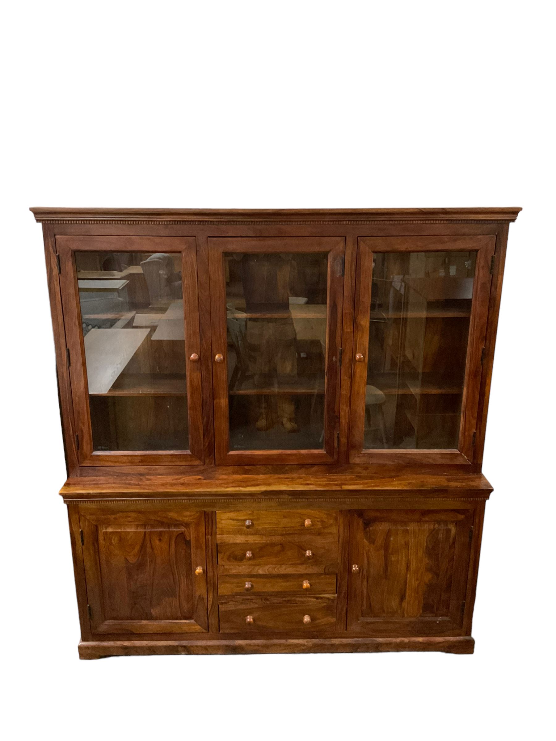 Large hardwood display wall unit, the upper section fitted with three glazed doors enclosing six shelves, the lower section fitted with four central drawers flanked by two panelled cupboards