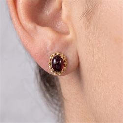 Pair of 9ct gold cabochon garnet stud earrings, stamped