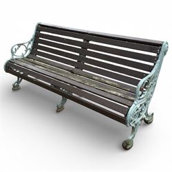 Victorian cast iron garden bench with dark wooden slats and ornate green painted ends.