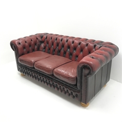 Three seat Chesterfield sofa upholstered in deep buttoned Ox blood leather, turned supports, W185cm