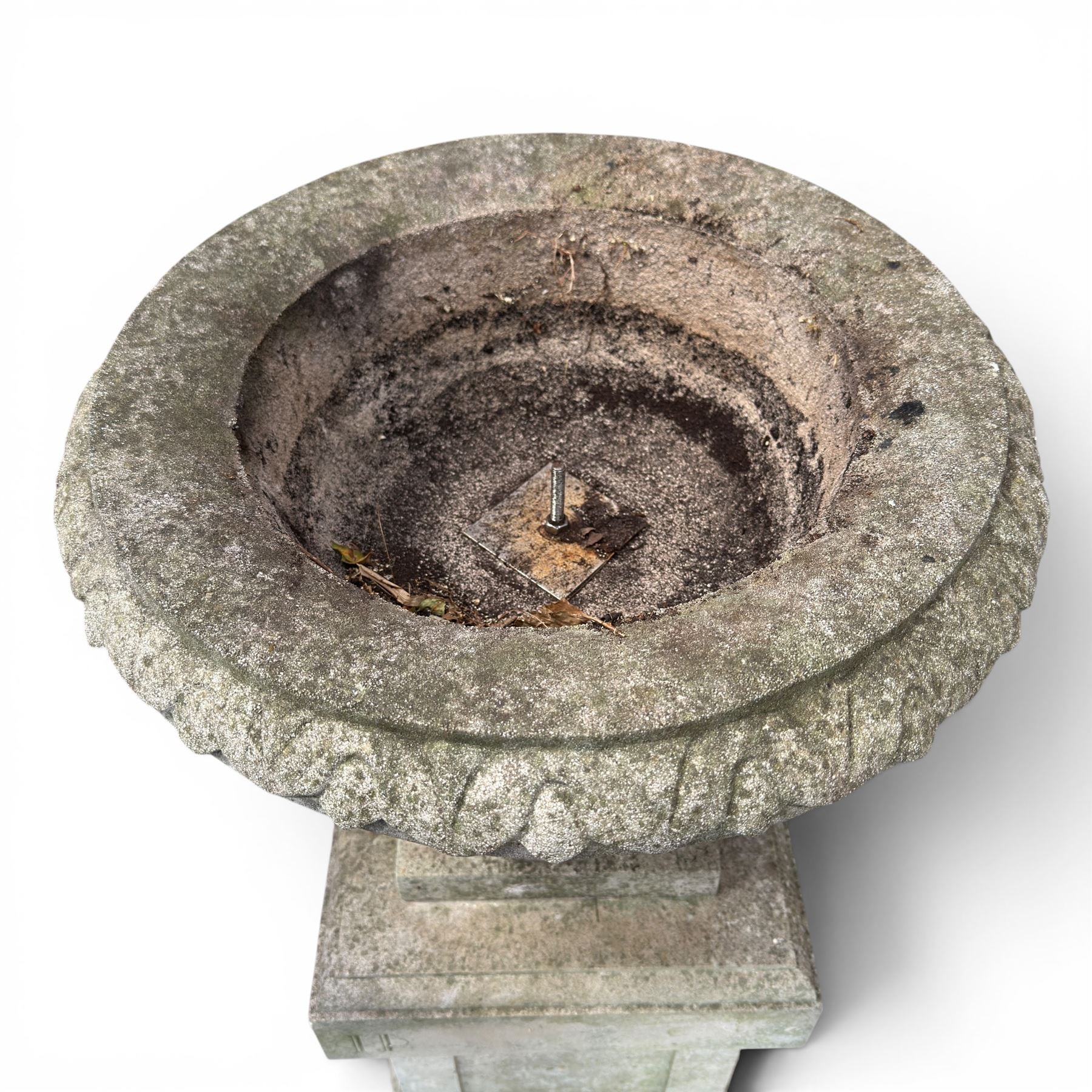 Pair of weathered cast stone Neoclassical design garden Kylix shape urns, foliate moulded rim over a gadrooned underbelly, the scalloped socle over a rectangular pedestal with faux-panelled sides, stamped with stylised ‘H’ monogram