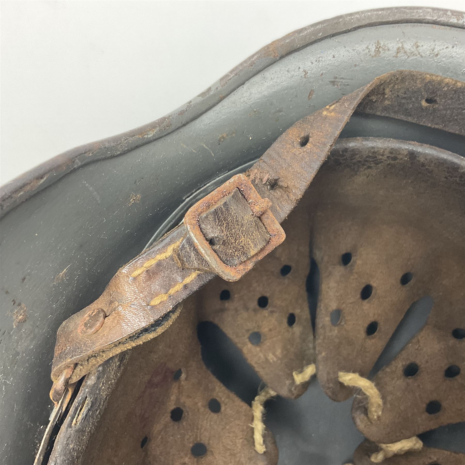 WW2 German Infantry M40 steel helmet with tropical finish and traces of single decal; with chin strap and leather liner marked 57 twice in red; back apron stamped 11 38