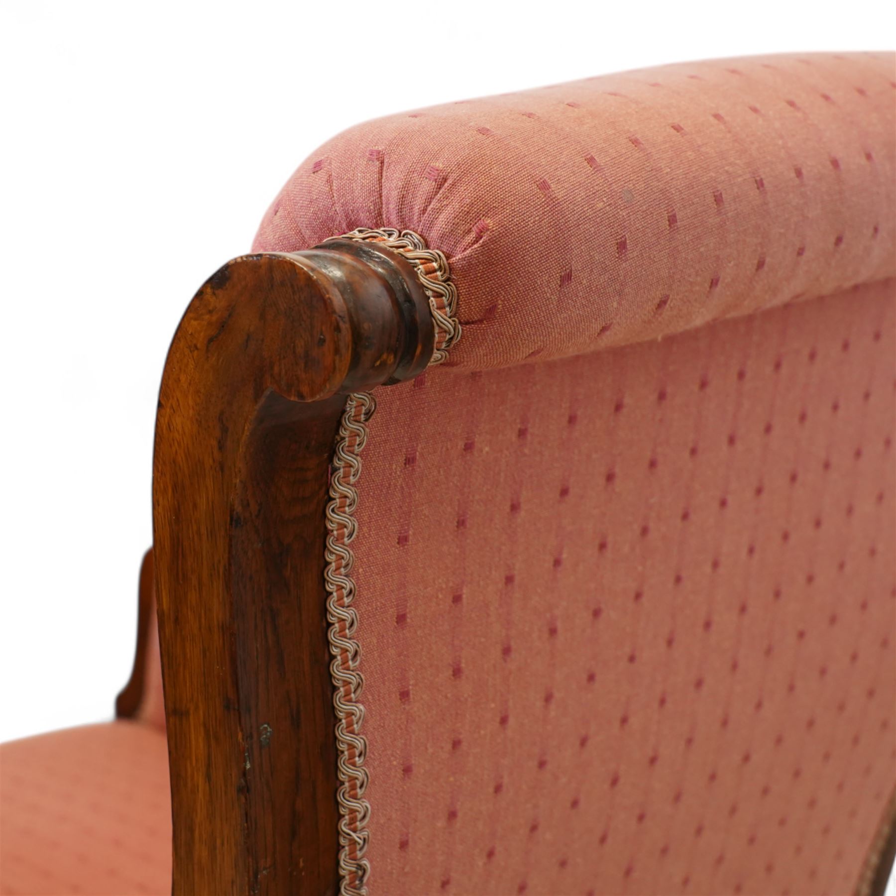 Victorian mahogany framed armchair, upholstered in salmon pink dot patterned fabric, the moulded arms with carved scroll terminals, raised on turned and fluted front legs and swept back legs, all with castors